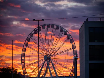 Blick von oben auf ein Riesenrad im Dämmerlicht