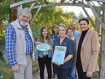 „Natur im Garten“: Harald Schäfer (l.) überreichte Prof. Dorothee Benkowitz (M.) Urkunde und Plakette. PHKA-Prorektorin Prof. Annette Worth (r.) gratulierte zur Auszeichnung. Foto: PHKA