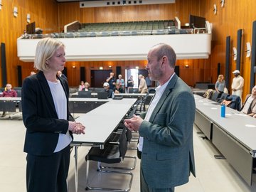 Yvette Melchien und Prof. Götz Schwab im Gespräcjh. Im Hintergrund der Bürgersaal der Stadt Karlsruhe.
