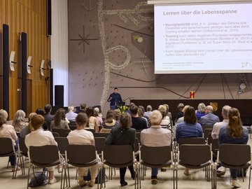 Prof. Skulmowski neben der Präsentationsleinwand und vor Publikum biem Vortrag im Bürgersaal bei PHKA im Rathaus.