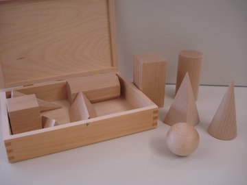 Verschiedene Körper aus Holz auf einem Tisch: Würfel, Kugel, Quader, Kegel usw,