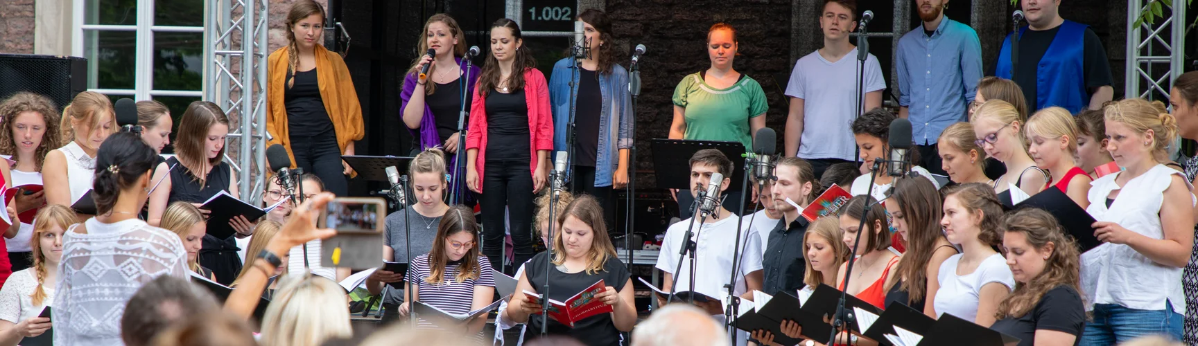 Der Hochschulchor bei einem Auftritt beim Sommerfest auf dem Campus