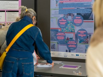 Posterausstellung bei PHKA im Rathaus. eine Zuschauerin begutachtet auch die Mitmachangebote vor der Posterwand.