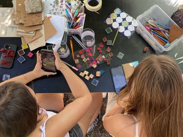 Eindrücke vom Kunstkiosk 2026: Zwei Studentinnen legen am Kiosk die Materialien bereit