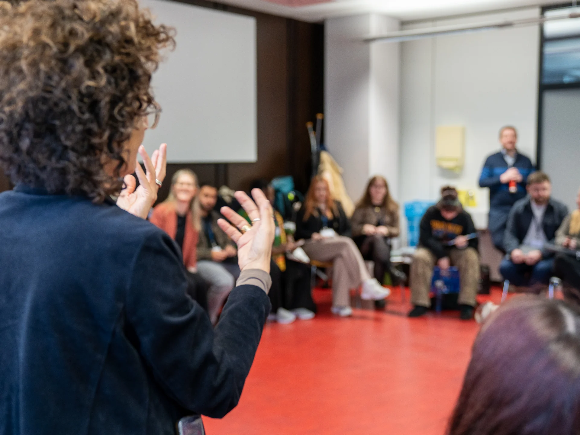 A person speaking in front of a group.