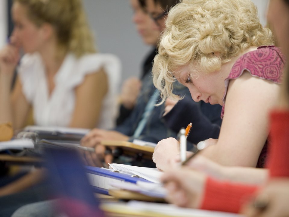 Eine Studentin macht sich Notizen während einer Vorlesung
