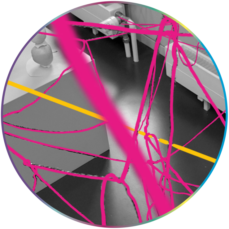 Ein graustufiger Innenraum mit Möbelstücken und technischen Elementen ist zu sehen. Darüber liegen zahlreiche unregelmäßige, pinke Linien wie gespannte Fäden, dazu verläuft eine einzelne gerade gelbe Linie diagonal durchs Bild. Die bunten Linien überlagern den Raum wie ein Netzwerk oder Geflecht.