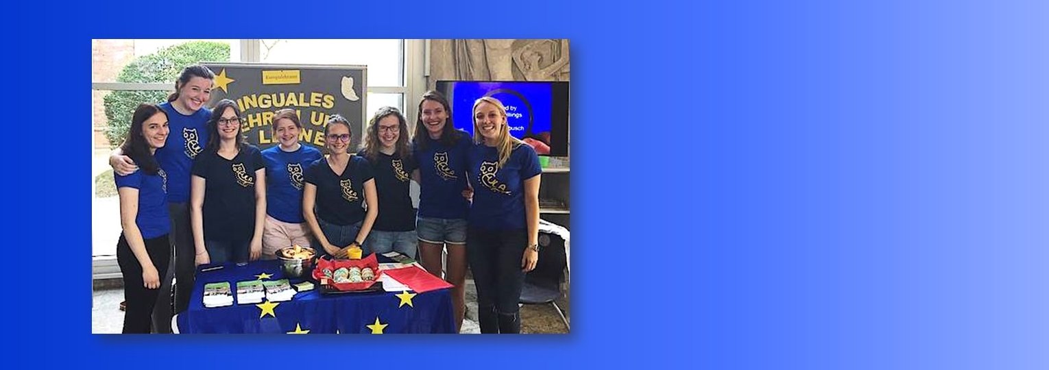 Studentinnen in blauen T-Shirts der Eula-Fachschaft stehen an einem Info-Stand.