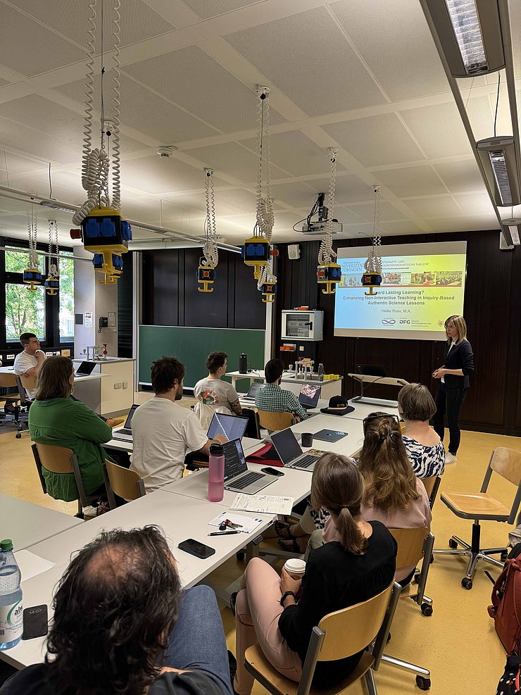 Zuhörende beim Vortrag von Heike Russ in einem Seminarraum sowie Heike Russ beim Vortragen, im Hintergrund sind ihre Folien zum Vortrag zu sehen