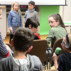 Auf dem Bild sind vortragende Kinder in einer Diskussion zu sehen.